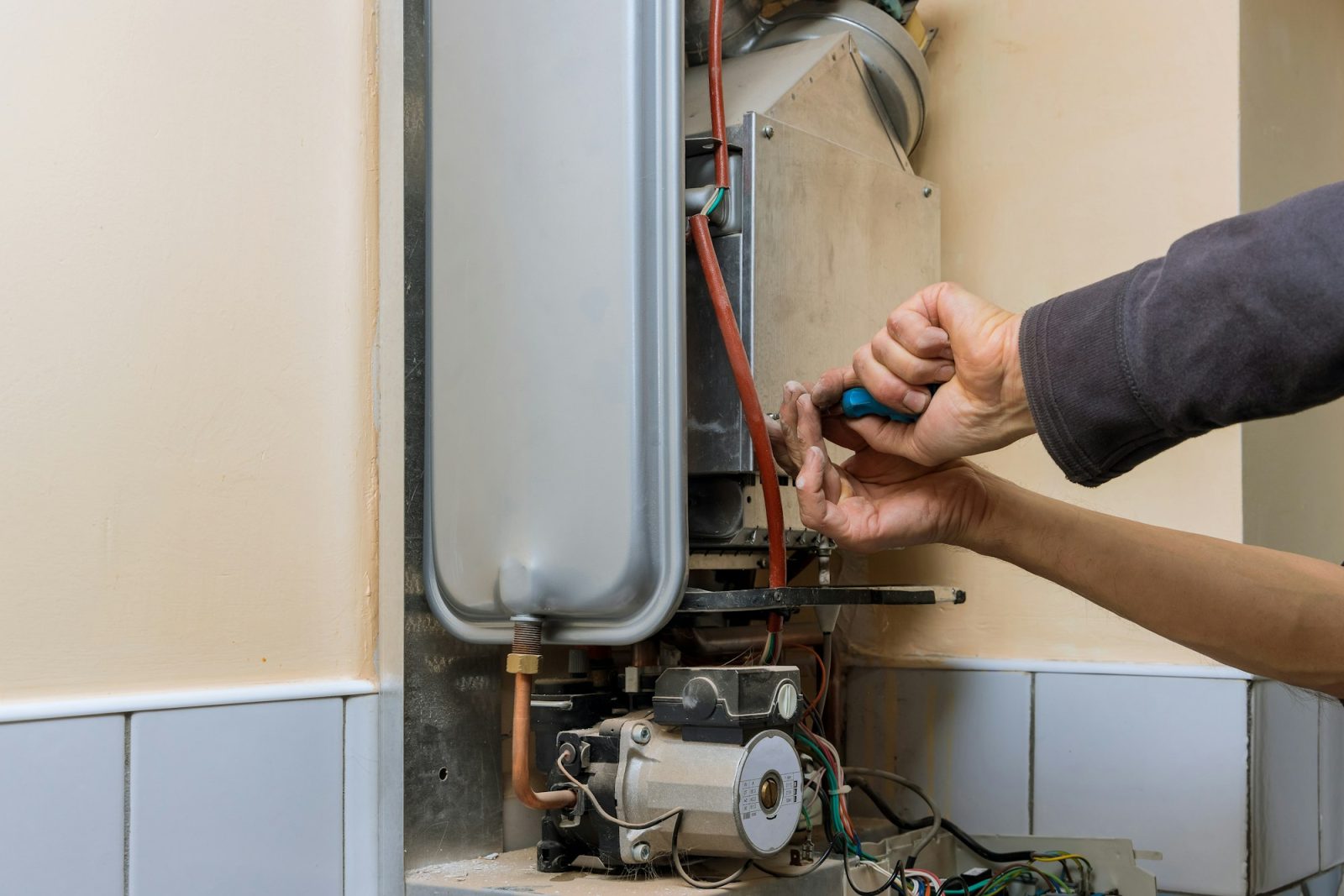 Professional plumber servicing a central heating system boiler